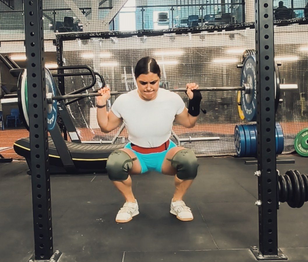 Elaine mid-squat under a loaded barbell